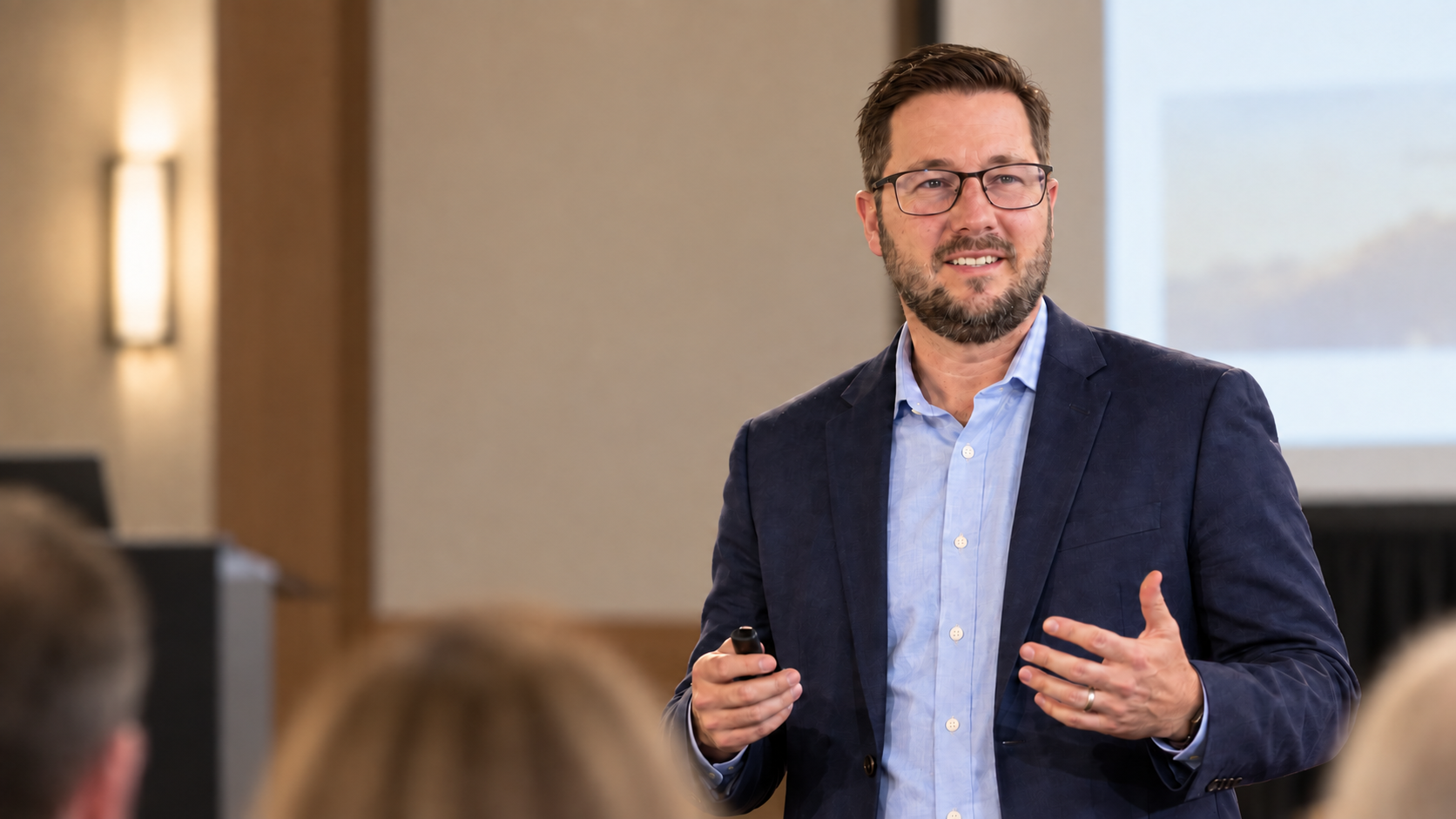 Ben Dewey presenting to an audience in a professional conference room